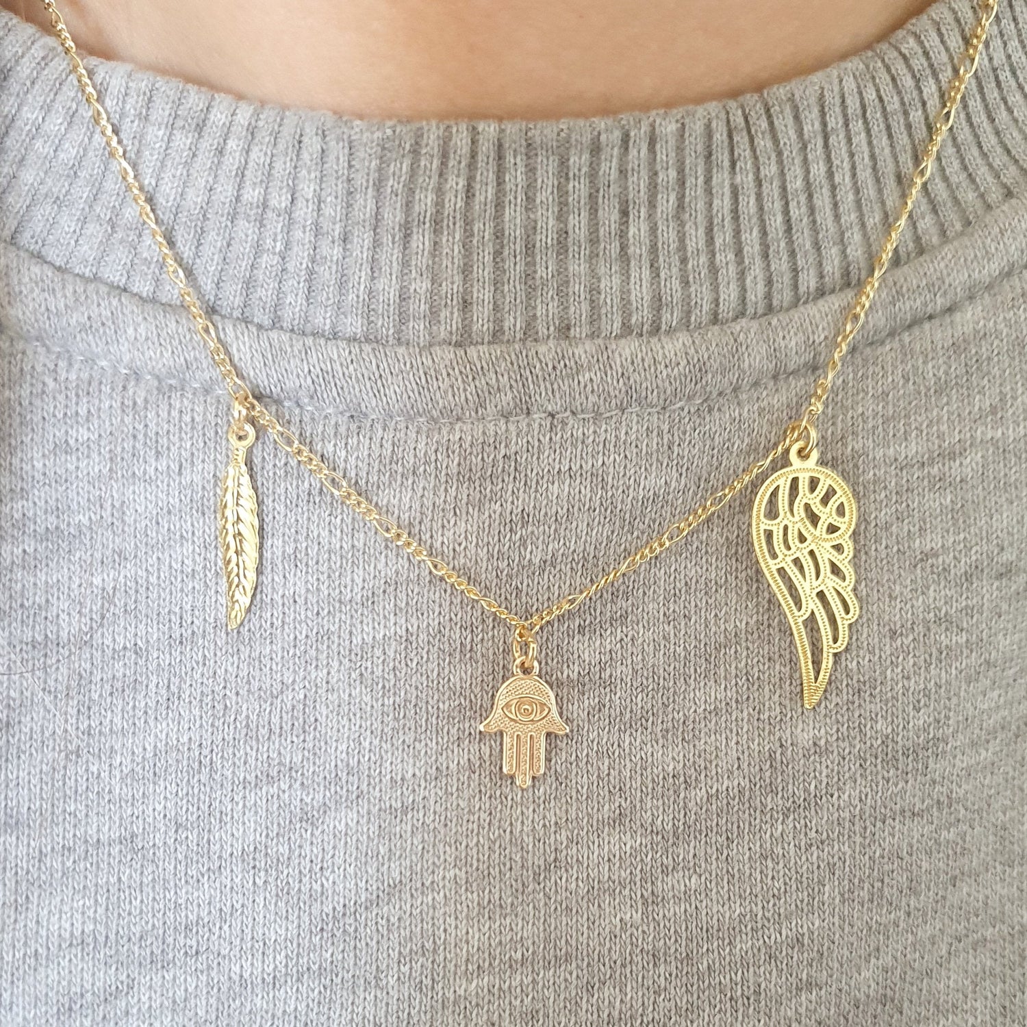 Gouden 14k Gold Filled ketting met bedels van een veer, hamsa hand en engelenvleugel uit de Charms & Luck collectie van lux & luz.