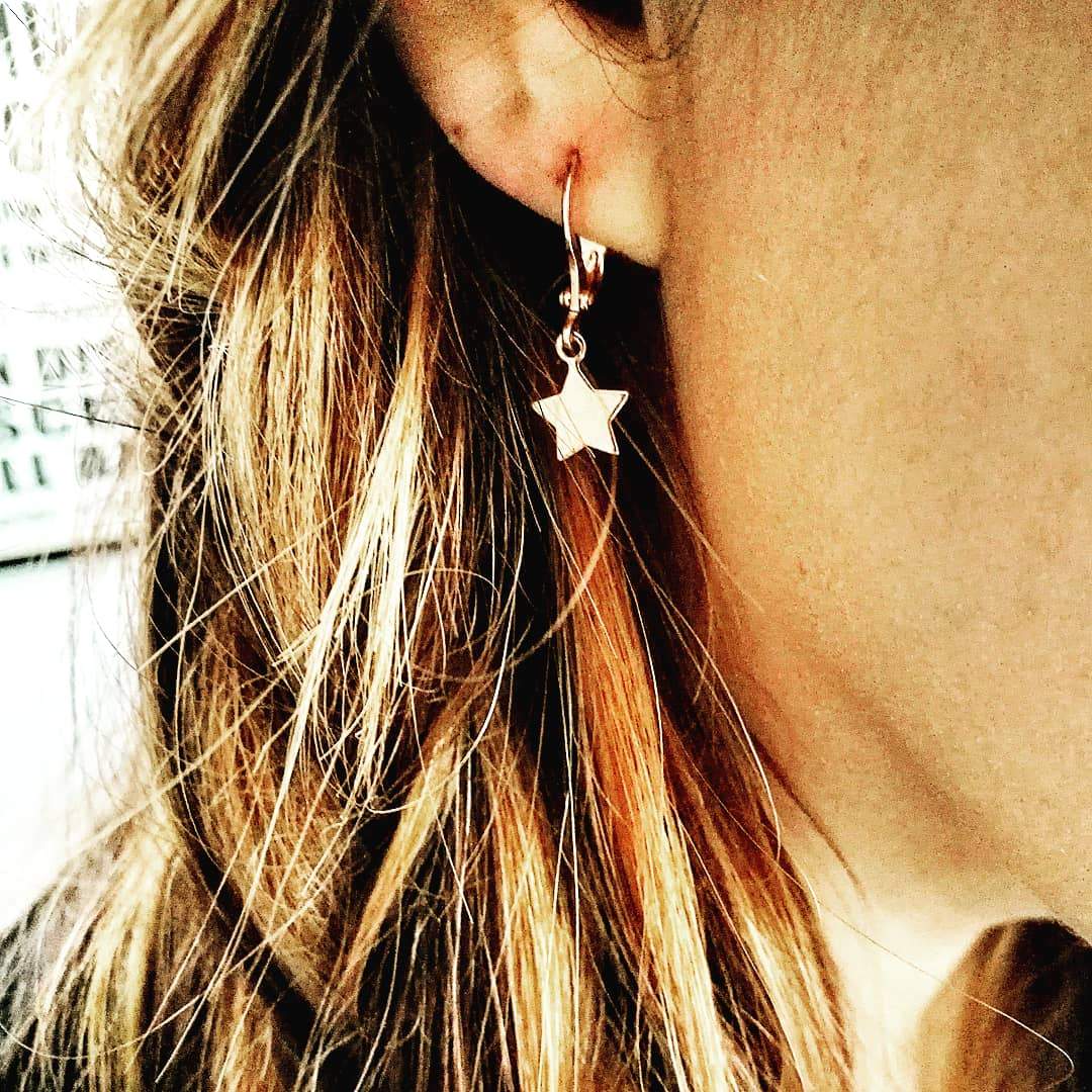 Sieraden set goud met kleine ster hangers gedragen door model hypoallergeen