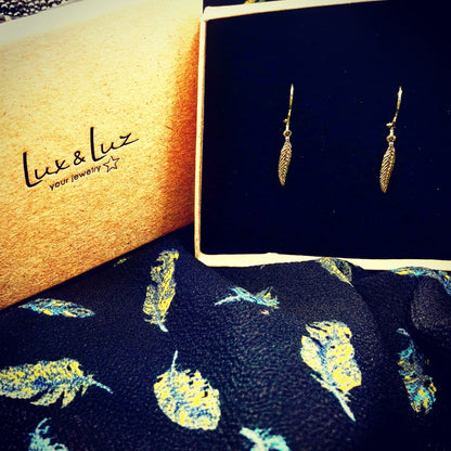 Luxe zwart sieradendoosje van lux & luz met gouden veertjes oorbellen, een betekenisvol en hypoallergeen cadeau voor gevoelige oren.