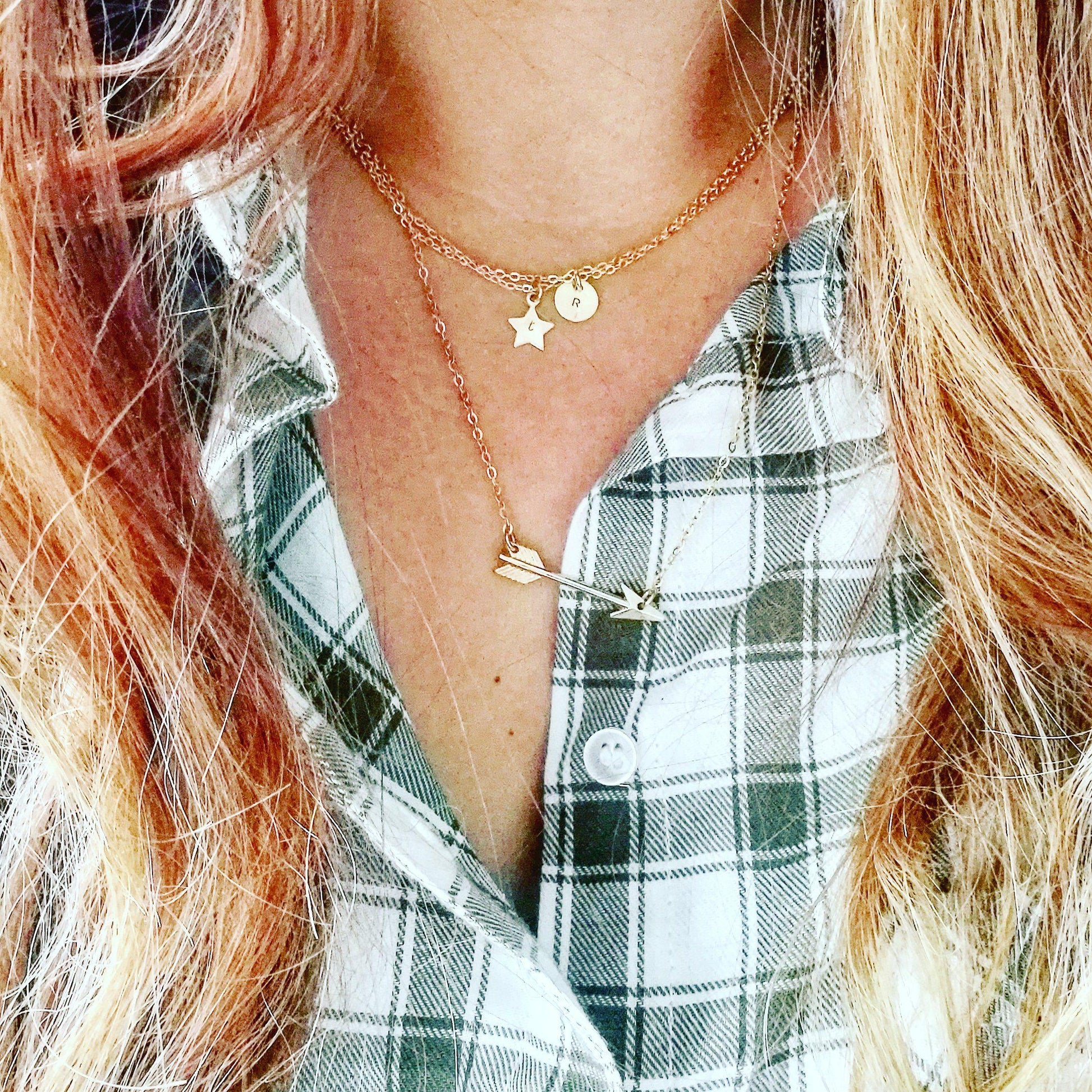 Vrouw met een eclectische stijl draagt de gouden pijl ketting; een symbool voor focus, richting en een eigenzinnig karakter.