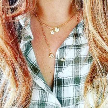 Vrouw met een eclectische stijl draagt de gouden pijl ketting; een symbool voor focus, richting en een eigenzinnig karakter.