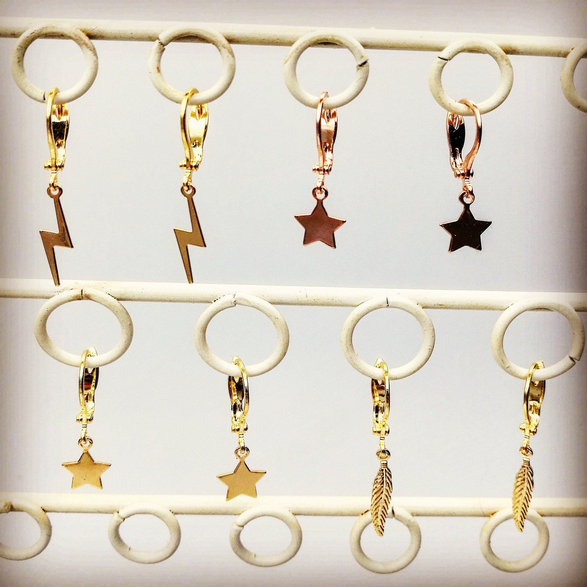 Collectie waterproof gouden oorbellen en hangers van 14k gold filled op een sieradenrekje in Nederlands atelier