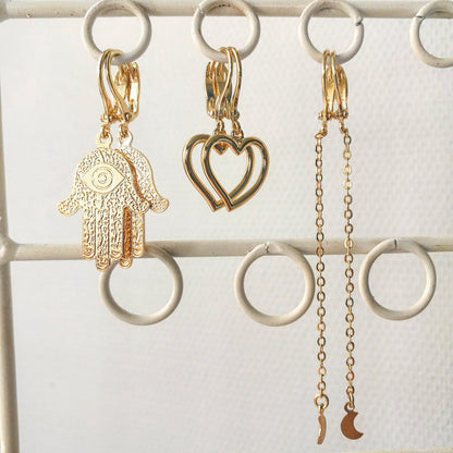 Detail van micro-gepolijste gouden Hamsa Hand studs, ethisch sieraad uit Nederlands atelier van duurzame investment-grade kwaliteit.